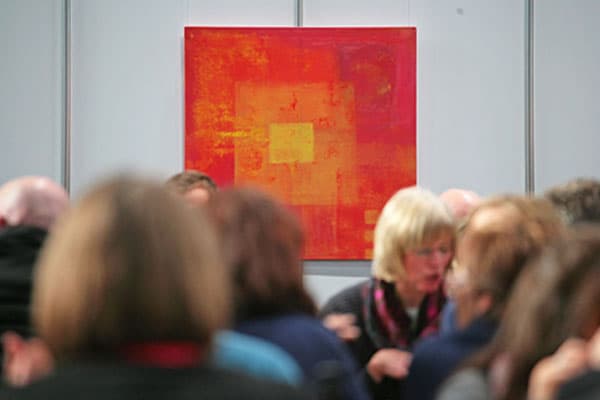 Besuchergruppe vor einem rot-orangefarbenen Gemälde